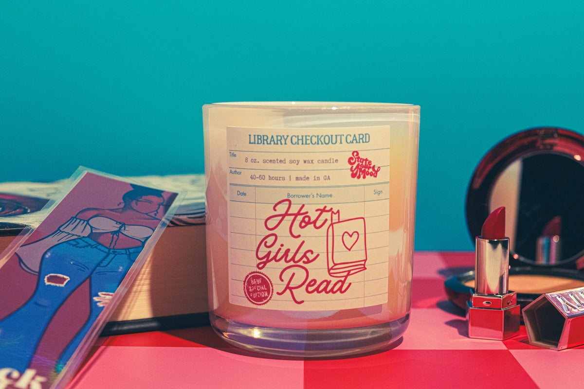 Candle with a 'Hot Girls Read' label on a colorful background