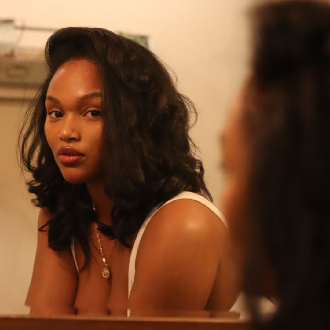 black woman looking in mirror